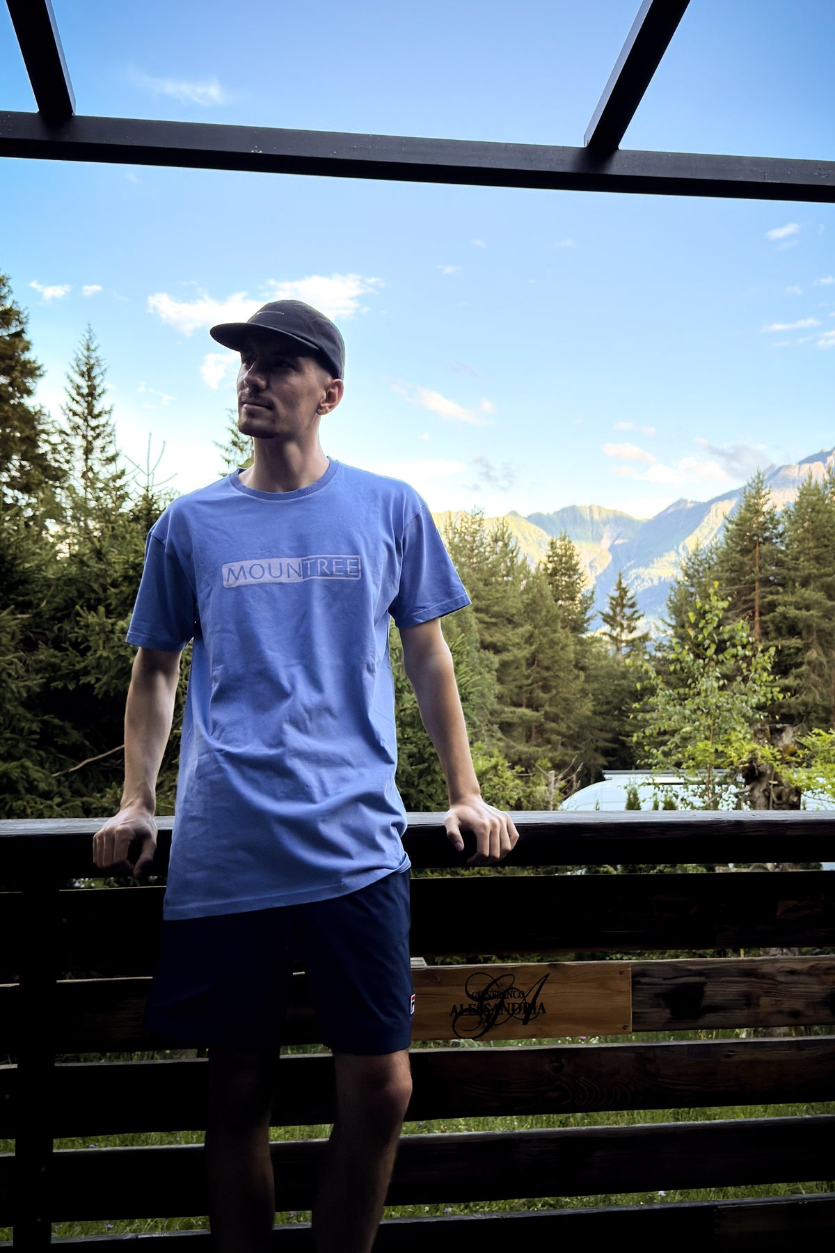 Quirin im MOUNTREE Frame Logo Tee Blue vor Bergkulisse
