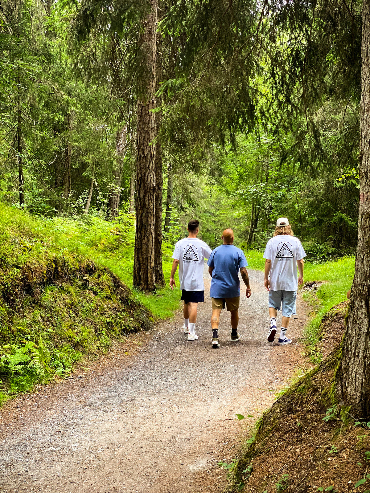 Drei MOUNTREE Models auf einem Waldweg mit Original Logo Tee White und Frame Logo Tee Blue