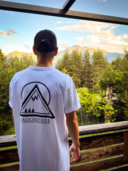 Quirin im MOUNTREE Original Logo Tee White mit großem Mountain Logo vor Bergkulisse